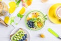 Corn pads, kiwi, blueberries, winter cherries and crispy bread with berries on a white wooden background