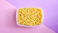 Corn in a plastic container for long-term storage. Deep freezing of vegetables. Frozen food vegetables on color background Royalty Free Stock Photo