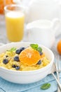 Corn porridge with fresh blueberry, orange and pine nuts in bowl served for breakfast