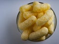 Corn Puffs in a Glass Bowl. Crunchy Flavored Puffed Snacks. Party, Movie Snacks Royalty Free Stock Photo