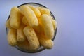 Corn Puffs in a Glass Bowl. Crunchy Flavored Puffed Snacks. Party, Movie Snacks