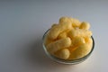 Corn Puffs in a Glass Bowl. Crunchy Flavored Puffed Snacks. Party, Movie Snacks