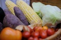 Corn, purple sweet potato, tomatoes, lettuce and gooseberries in basket. vegetable harvest from farm Royalty Free Stock Photo