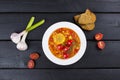 Corn soup with cherry tomatoes in white plate on wooden background with garlic and bread. Top view Royalty Free Stock Photo