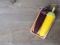 The corn stalks boiled and delicious on the wooden dish and the dish on wooden table. The color of corn is yellow and brown. copy Royalty Free Stock Photo