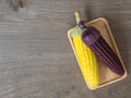 The corn stalks boiled and delicious on the wooden dish and the dish on wooden table. The color of corn is yellow and brown. copy Royalty Free Stock Photo