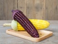 The corn stalks boiled and delicious on the wooden dish and the dish on wooden table. The color of corn is yellow and brown. copy Royalty Free Stock Photo