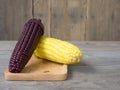 The corn stalks boiled and delicious on the wooden dish and the dish on wooden table. The color of corn is yellow and brown. copy Royalty Free Stock Photo