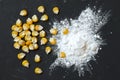 Corn starch with yellow grains on a black background, top view. Corn white starch and yellow kernels on the table. Starch and corn Royalty Free Stock Photo