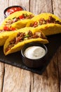 Corn tacos filled with minced beef and vegetables served with sauces close-up. vertical Royalty Free Stock Photo