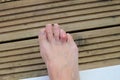 Ladies sore toe on decking Royalty Free Stock Photo