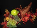 cornacopia filled with fruit, surrounded by fall leaves Royalty Free Stock Photo