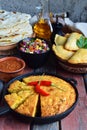 Cornbread and other mexican food - tacos, salsa with tomato, red onion, lime, cilantro, corn and hot pepper sauce, empanadas. Copy Royalty Free Stock Photo