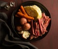 Corned beef,cabbage,carrots and red potatoes on black plate