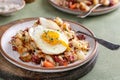 Corned beef hash with potatoes and carrots with fried egg on top Royalty Free Stock Photo