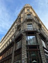 Corner of an ancient building with carved balconies, stucco and large windows against the sky