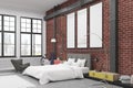 Corner of bedroom interior with brick walls and three narrow vertical posters on them. Royalty Free Stock Photo