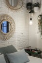 Corner of a bedroom with a white brick wall, hanging plants and cushions Royalty Free Stock Photo