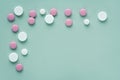 Corner border of white and pink round pills on a light green background Royalty Free Stock Photo