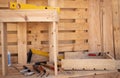 Corner of the carpenter full of wooden panels to be recycled. Wood on background. Chair in progress. Tools on the table