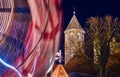 Corner of the cathedral of Braunschweig with a part of a moving Ferris wheel, night shot with intentional motion blur Royalty Free Stock Photo