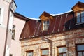 Corner of the courtyard of old building houses with windows attic and downpipe