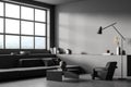 Corner of minimalist dark grey living room with ledge, sofa and armchair