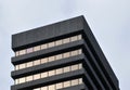 Corner detail of a typical brutalist style 1960s concrete office building with geometric concrete framework against a grey Royalty Free Stock Photo