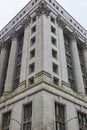 Corner of grey building with pillars and columns on overcast day with gloomy, ominous sky, Chicago Royalty Free Stock Photo