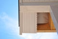 Corner of house with eaves against summer background.