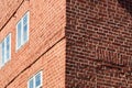 Corner of a house made of red bricks with one wall in sunshine and the other in shadow, abstract Royalty Free Stock Photo