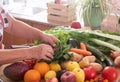 Corner of the kitchen and two hands of a senior woman working to do a fresh fruit salad. Wooden table with a large group of Royalty Free Stock Photo