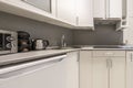 corner of a kitchen with white wooden cabinets, a gray countertop, Royalty Free Stock Photo