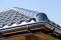 Corner of the new modern house with roof and gutter under blue sky