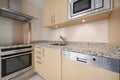 Corner of a newly installed modern kitchen with pink granite worktops, light