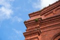 Corner of old Red Brick Church Building with Ferns Growing in Cracks and Blue Sky Royalty Free Stock Photo