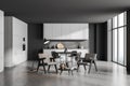 Corner of panoramic grey kitchen with seating area and round dining table Royalty Free Stock Photo