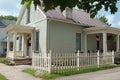 Corner Picket Fence with Small Stucco Cottage Royalty Free Stock Photo