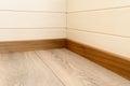 corner of the room with wood-paneled walls, wooden skirting boards and a wooden floor Royalty Free Stock Photo