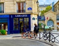 People waiting outside near a corner street library in Paris