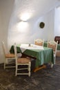 Corner, with table and four very nice chairs, under a porch of a restaurant with white walls and beautiful floor, in Graz.