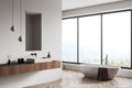 Corner view on bright bathroom interior with bathtub, panoramic window Royalty Free Stock Photo