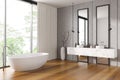 Corner view on bright bathroom interior with double sink, bathtub Royalty Free Stock Photo