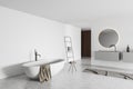 Corner view on bright bathroom interior with round mirror, bathtub Royalty Free Stock Photo