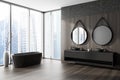 Corner view on dark bathroom interior with bathtub, round mirrors Royalty Free Stock Photo