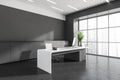 Corner view on dark grey office room interior with ceo table, desk with desktop computer, armchair, panoramic windows, concrete Royalty Free Stock Photo