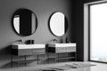 Corner view of grey bathroom wall with two round mirrors over vanities Royalty Free Stock Photo