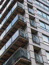 Corner view of a modern urban apartment building with black cladding and glass balconies reflecting other buildings Royalty Free Stock Photo