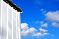 Corner of metal outbuilding with view of clouds behind