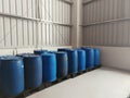 A corner of a warehouse with green plastic chemical drums on plastic black pallet Royalty Free Stock Photo